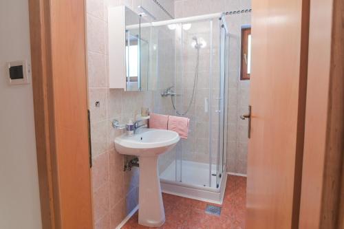 a bathroom with a sink and a shower at Apartma pod Rožem in Soča