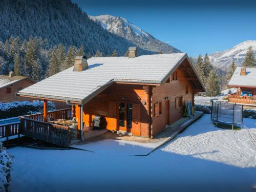 a log cabin in the snow with mountains in the background at Chalet Igel - OVO Network in Châtel