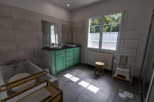 a bathroom with a green cabinet and a sink at Gîte du mouta in Saint-Justin