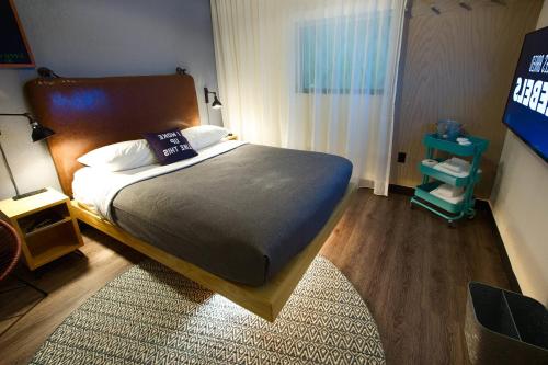 a bedroom with a large bed with a rug at MOXY New Orleans Downtown/French Quarter Area in New Orleans
