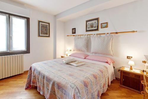 a bedroom with a large bed with pink pillows at Terrazza Valtellina in Grosio