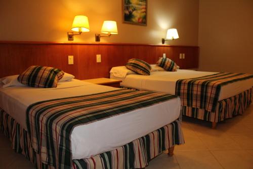 a hotel room with two beds with striped sheets at Marcopolo Suites Iguazu in Puerto Iguazú