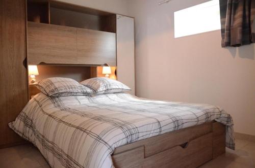 a bedroom with a large bed with a wooden headboard at Les prés saint jean in Champigny-sur-Aube