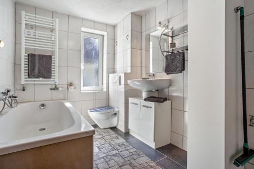 a bathroom with a tub and a sink and a toilet at Ferienwohnung bis zu 6 Per. 65 M² in Wolgast