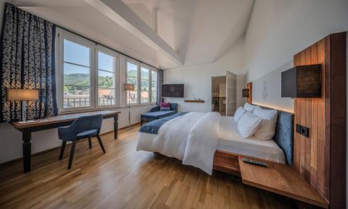 a hotel room with a bed and a desk and a desk at VILLA LINDE Seehotel in Bodman-Ludwigshafen