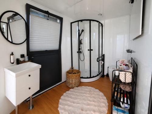 a bathroom with a shower and a sink and a mirror at Mazurska Osada Just in Łupki