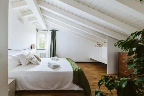a bedroom with a bed with white sheets and a window at Casa Rucola in Sestri Levante