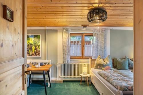 a living room with a bed and a table and a table sidx sidx at Haus Elfriede Schmid in Bad Bayersoien