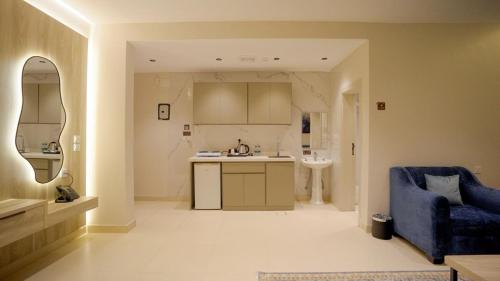a kitchen with a blue couch and a blue chair at منتجع اغصان الشفا in Ash Shafa