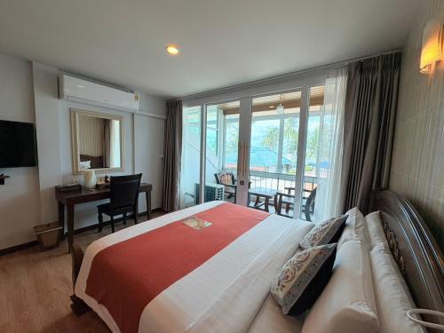 a bedroom with a bed and a desk and a window at Talay Sai @ Thung Wua Laen in Chumphon