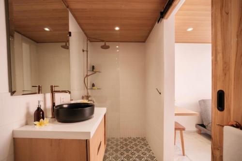 a bathroom with a sink and a black bowl at Santai Studios in Badung
