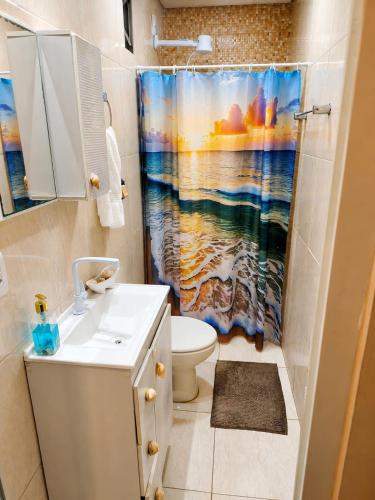 a bathroom with a sink and a shower curtain at Apartamento térreo climatizado próximo a praia in Itapema
