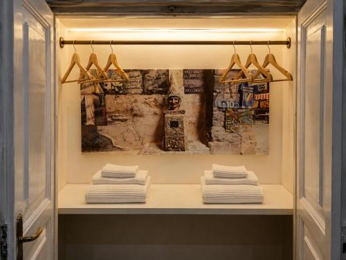 a shelf with towels and a painting on the wall at Relais Principe Umberto in Naples
