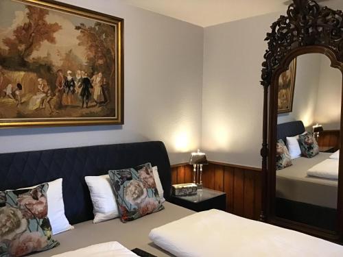 a hotel room with a bed and a painting on the wall at Villa Merzbach - Wohnen wie im Museum mit Komfort in Untermerzbach