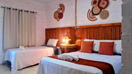 a hotel room with two beds with towels on them at POUSADA ALLES in Santo Amaro