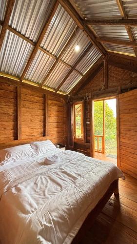 a large bed in a room with a wooden ceiling at Kuna GlampCamp in Gitgit
