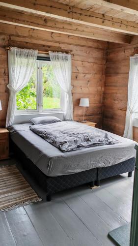 a bedroom with a large bed in a wooden room at Romantic farmhouse in Vaksdal
