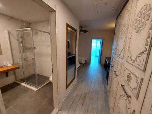 a bathroom with a walk in shower and a glass door at Assos Barbarossa Special Class Hotel in Behramkale