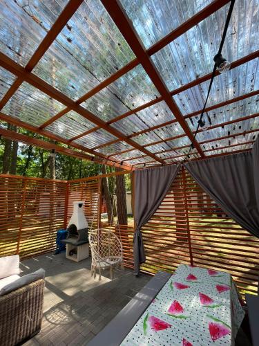 a patio with a pergola and a bed on a deck at W sosnowym lesie 2 in Lubniewice