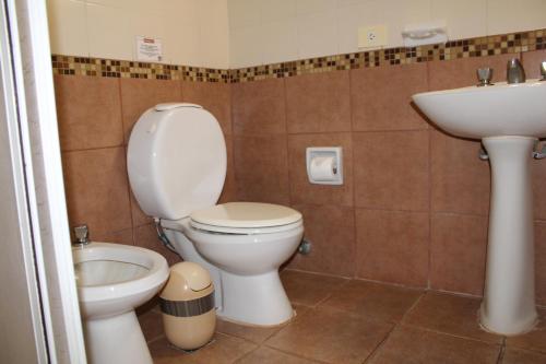 a bathroom with a toilet and a sink at Marcopolo Suites Iguazu in Puerto Iguazú