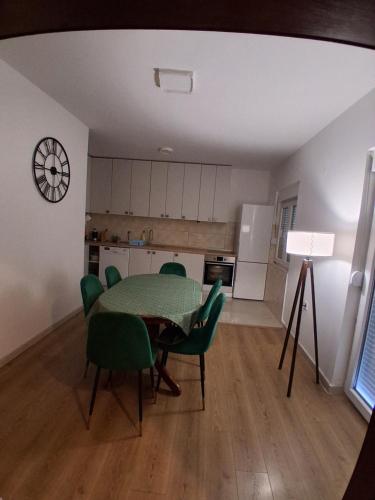 ein Wohnzimmer mit Tisch und Stühlen und eine Küche in der Unterkunft Radoš in Igalo