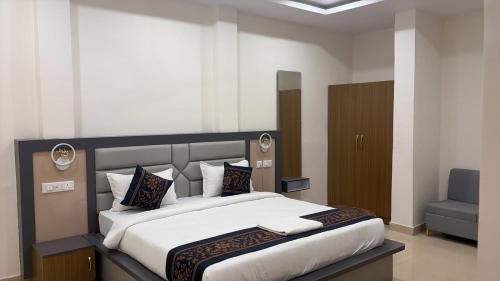 a bedroom with a large bed and a blue chair at The Kashi Dharohar in Varanasi