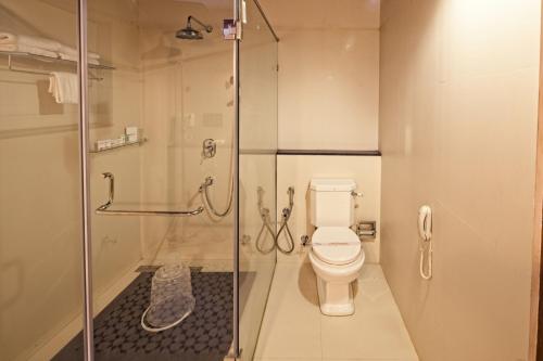 a bathroom with a toilet and a glass shower at Amritha Heritage in Trivandrum
