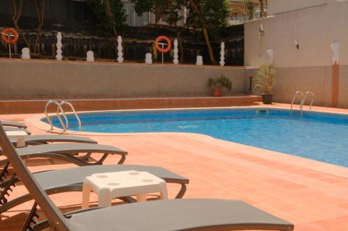 a swimming pool with lounge chairs and a swimming pool at Hotel Cassandra in El Arenal