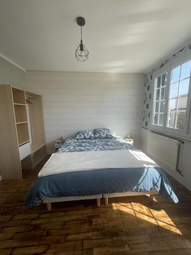 a bedroom with a large bed with a blue comforter at gîte Théalys- proche Puy du Fou in La Petite-Boissière