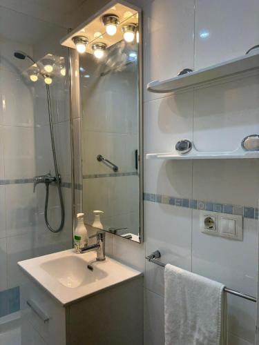 a bathroom with a sink and a shower with a mirror at La Explanada in Alicante