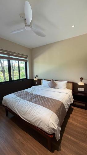 a bedroom with a large bed with a ceiling fan at Gemstay Hotel Hue in Thôn Trường Giang