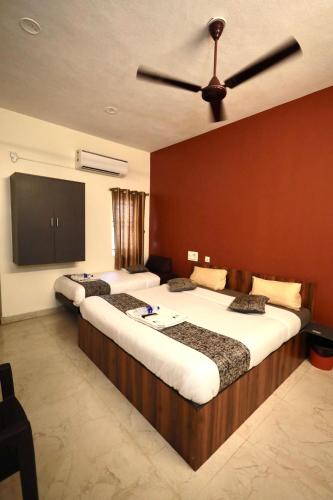 a hotel room with two beds and a ceiling fan at Olive By David Residency - Just 4 Kms from Meenakshi Amman Temple in Madurai