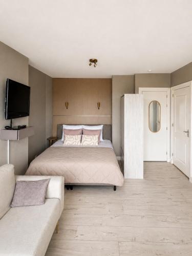 a bedroom with a large bed and a couch at Maison Lumière - Private Rooftop terrace in Amsterdam