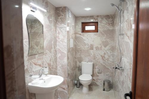 a bathroom with a sink and a toilet and a mirror at Къща за гости Мекана in Borino