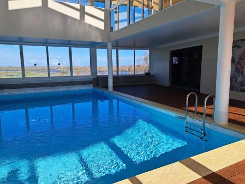 a large swimming pool with blue water in a building at Village Naturiste NATUREVA & SPA - Babylone NATURISME in Cap d'Agde