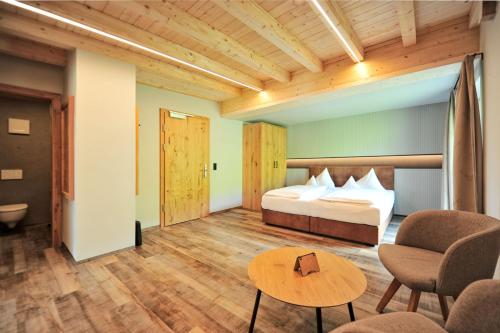 a hotel room with a bed and a table and chairs at Pension Garni Hochmoos in Lermoos