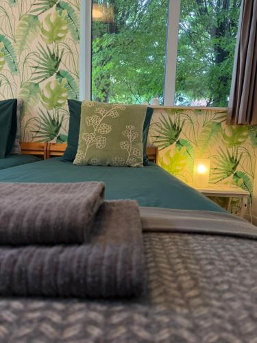 a bedroom with a bed with a large window at De Oude Kleuterschool in Zoelen
