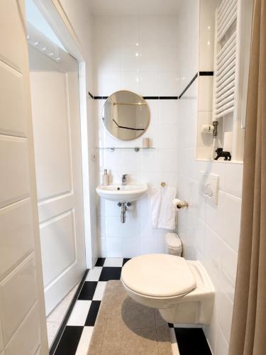 a white bathroom with a toilet and a sink at Maison Lumière - Private Rooftop terrace in Amsterdam