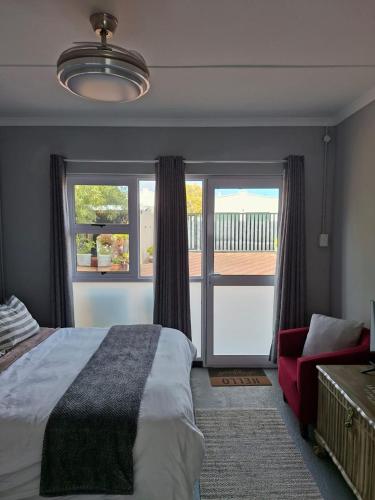 a bedroom with a bed and a large window at Koeroebees 1 in Springbok