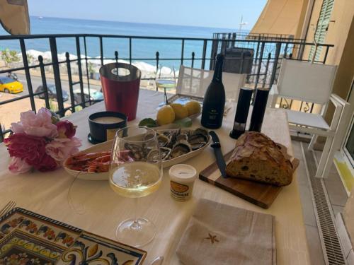 a table with food and a view of the ocean at Victoria Beach Front de Mer Luxury Apartment in Menton