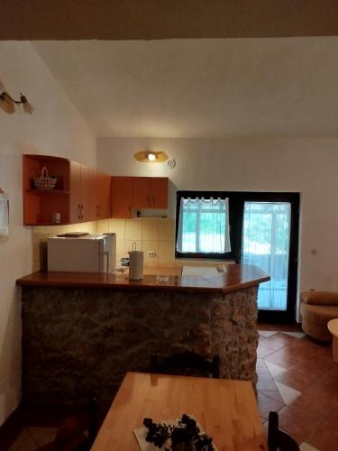 a kitchen with a stone counter and a table at Studio apartman Hrast in Seline