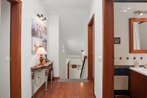 a hallway with a sink and a table with a lamp at Casa Do Cerro in Luz de Tavira