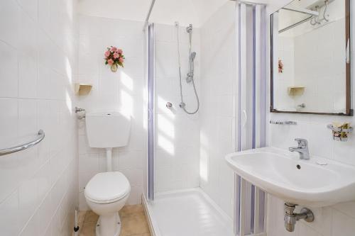 a white bathroom with a toilet and a sink at Casa Natura Gargano in Monte SantʼAngelo