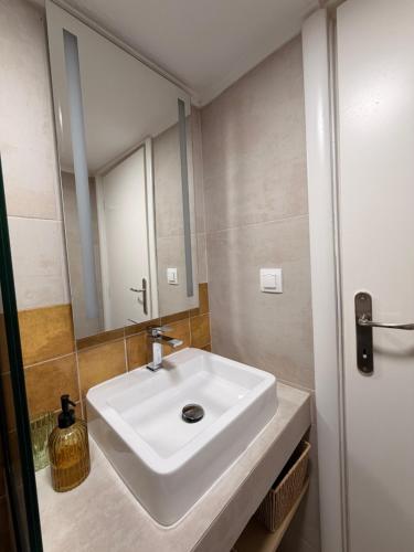 a bathroom with a white sink and a mirror at Aurora Suite in Xanthi