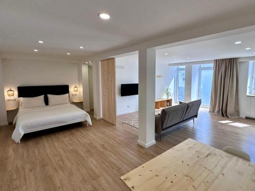 a bedroom with a bed and a couch and a television at UpTown Apartments in Horta