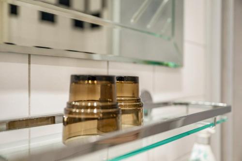 two jars sitting on a glass shelf in a kitchen at Bungalow Westerland Kampstrasse in Westerland