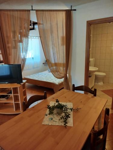 a room with a wooden table with flowers on it at Studio apartman Hrast in Seline