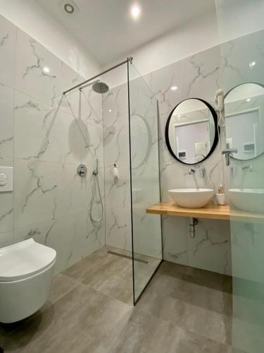 a bathroom with a shower and a toilet and a sink at Merly Hotel in Përmet