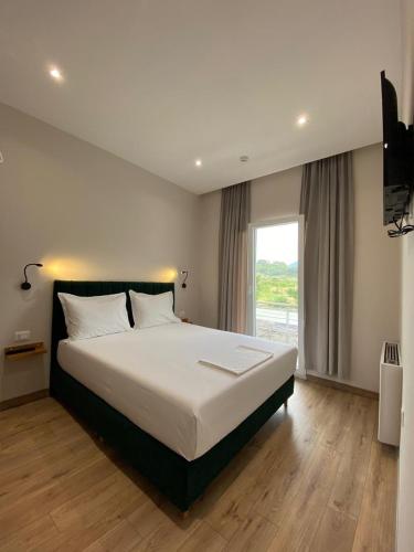 a bedroom with a large bed and a large window at Merly Hotel in Përmet