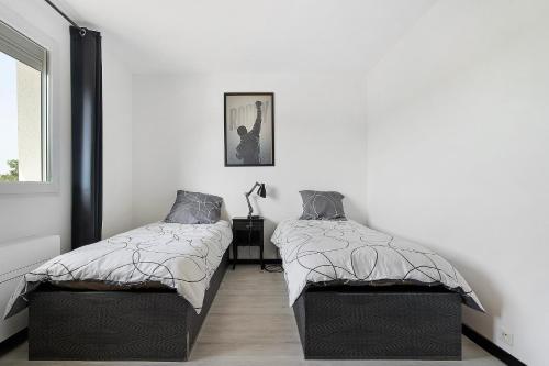 two beds in a room with white walls at Villa Alfaro in Saint-Cernin-de-Larche